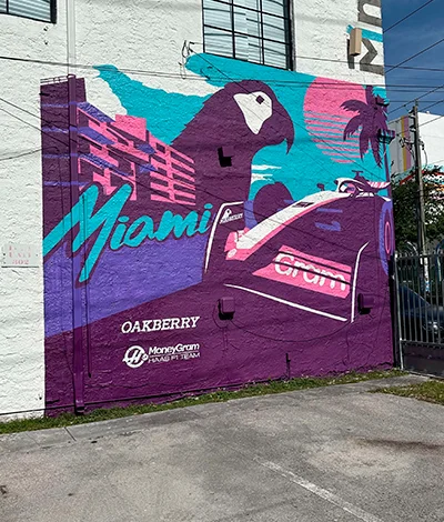 A mural of a race car and OAKBERRY's Logo a building